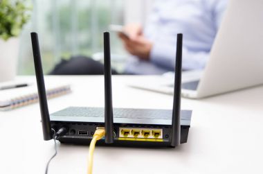 Kablosuz yönlendirici ve evde bir akıllı telefon kullanan adam