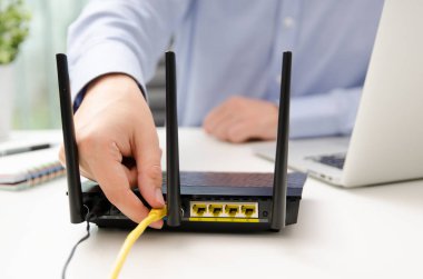Adam Ethernet kablosu yönlendiriciye takılan..