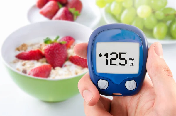 Diabetes haciendo pruebas de nivel de glucosa. Frutas en segundo plano — Foto de Stock