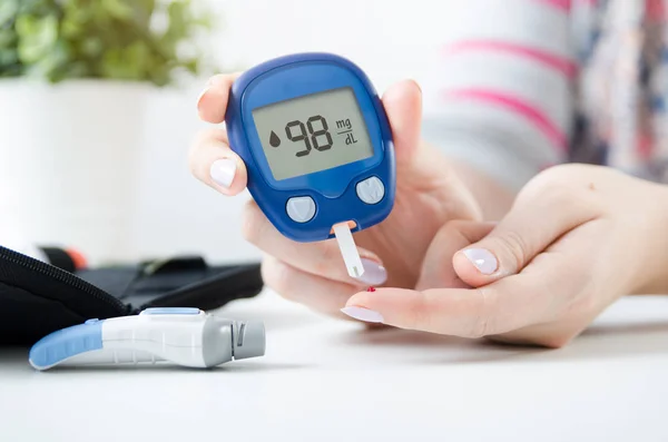 Kobieta, kontrola poziomu cukru we krwi przez glukometrem — Zdjęcie stockowe