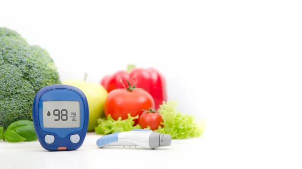 Glucometer en Schedellozen op groenten achtergrond — Stockfoto