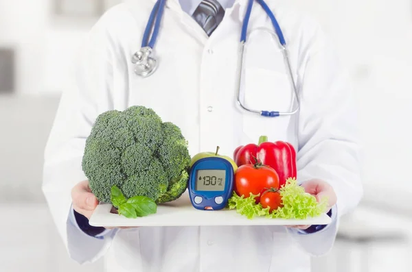 Médecin tenant légumes et fruits sur un plateau — Photo