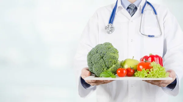 Doctor holding vegetables and fruits on a tray — Stock Photo, Image