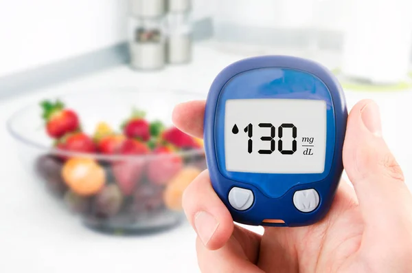 Diabetes haciendo pruebas de nivel de glucosa. Frutas en segundo plano —  Fotos de Stock