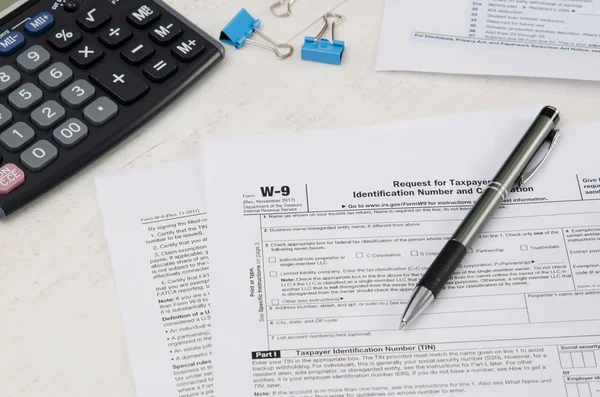 Formulário de imposto dos EUA W-9 com caneta e calculadora — Fotografia de Stock