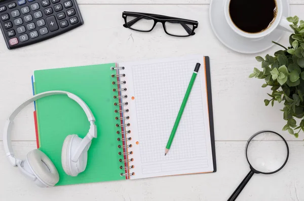 Office desk table layout with headphones and supplies