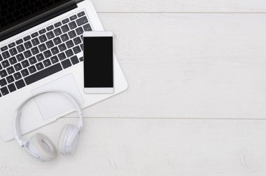 Ofis resepsiyon masası dizüstü bilgisayar, akıllı telefon ve kulaklık.