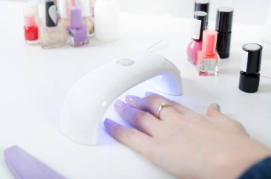UV ışık kullanan kadın kurutma makinesi. Manikür, spa salonu konsept.