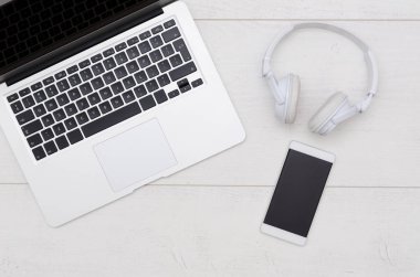 Ofis resepsiyon masası dizüstü bilgisayar, akıllı telefon ve kulaklık.
