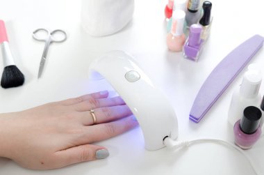 UV ışık kullanan kadın kurutma makinesi. Manikür, spa salonu konsept.