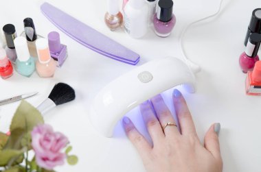 UV ışık kullanan kadın kurutma makinesi. Manikür, spa salonu konsept.