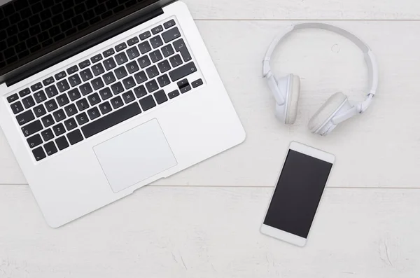 Mesa de escritorio de oficina con laptop, smartphone y auriculares . — Foto de Stock