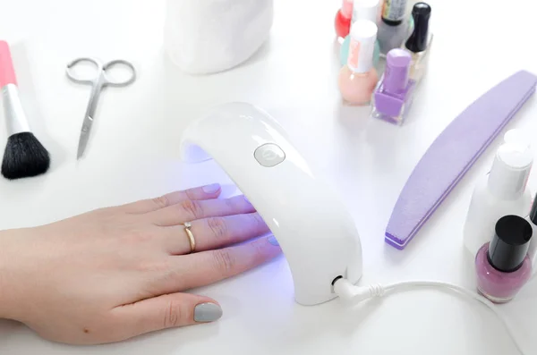 Woman using UV light dryer. Manicure, spa salon concept.