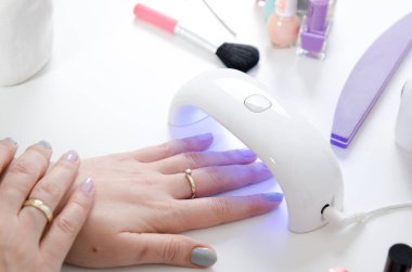UV ışık kullanan kadın kurutma makinesi. Manikür, spa salonu konsept.