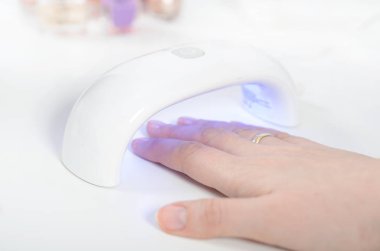 UV ışık kullanan kadın kurutma makinesi. Manikür, spa salonu konsept.