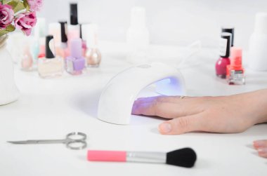 UV ışık kullanan kadın kurutma makinesi. Manikür, spa salonu konsept.