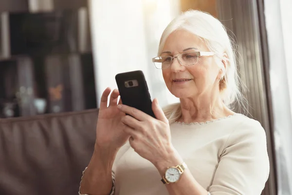 Mooie Senior vrouw texting thuis — Stockfoto