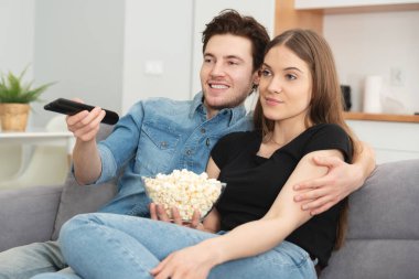 Kanepede televizyon izleyen bir çift. Televizyon, multimedya, eğlence konsepti