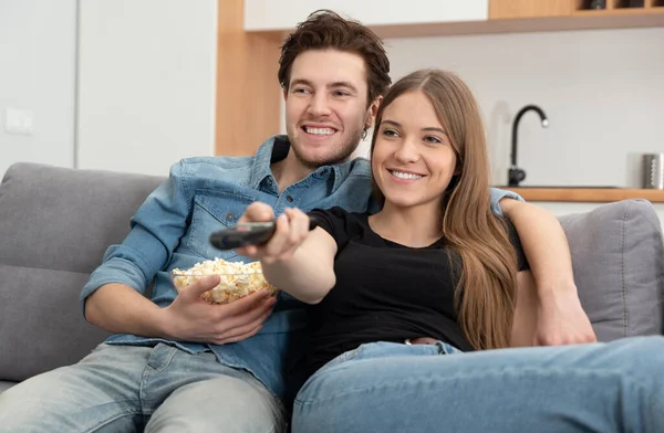 Couple watching TV on sofa. Television, multimedia, leisure concept