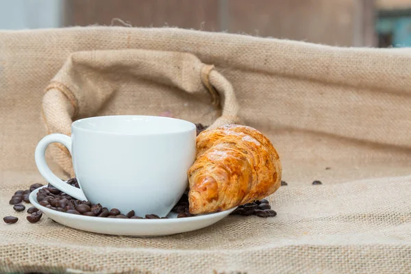Tasse à café avec Croissant et haricot sur la table — Photo