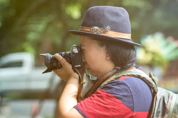 Hermosas mujeres asiáticas con cámara de puntería mochila en la selva bajo una llamarada de luz caliente —  Fotos de Stock