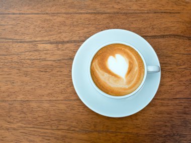 Kahve sanat latte üzerinde açık üzerinden sıcak ışık parlama ile ahşap, vintage kahve fincan