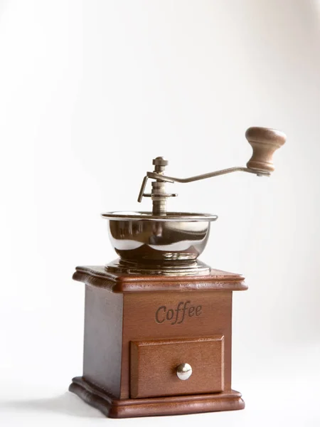 Old retro coffee mill on white background, vintage hand-mill with warm light flare Stock Photo