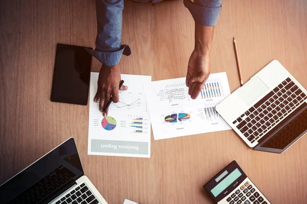 Top view of business report meeting which manager show sale report chart placing together with laptop and calculator on meeitng desk