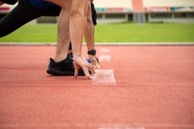 Formda ve kendinden emin iki adam başlama pozisyonunda koşmaya hazır. Erkek sporcu sprint 'e başladı.