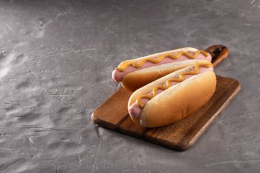 Tahtada hardallı sosisli sandviç. Sosisli sandviçler taş masada servis edilir. Metin için boş alan