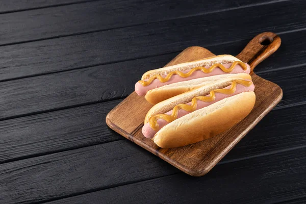 Hot Dogy Hořčicí Dřevěné Desce Hot Dogy Podávané Černém Stole — Stock fotografie