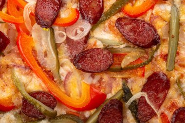 Masada taze pizza var. Lezzetli pizza. Domuz pastırmalı, sosisli, salamlı, pepperonili ve zeytinli büyük boy etli pizza. Akşam yemeği için ahşap masada ev yapımı lezzetli İtalyan pizzası. İtalyan mutfağı.