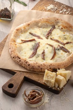 Masada taze pizza var. Napoli pizzası ya da ançüezli pizza. Akşam yemeği için ahşap masada ev yapımı lezzetli İtalyan pizzası. İtalyan mutfağı.