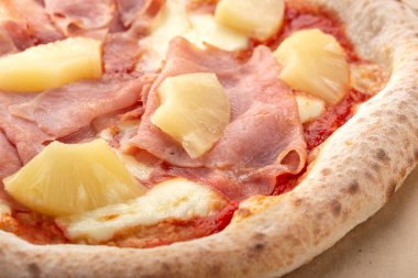 Masada taze pizza var. Ananaslı ve jambonlu pizza. Akşam yemeği için ahşap masada ev yapımı lezzetli İtalyan pizzası. İtalyan mutfağı.