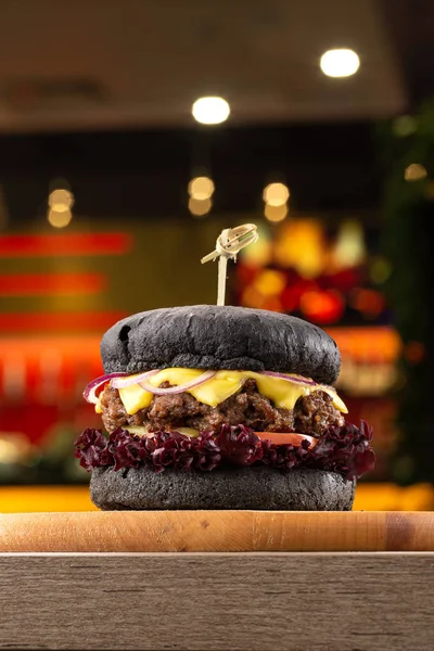 Tahta masada sulu pastırmalı burger. Lezzetli fast food ızgara taze lezzetli burger. Sığır eti, domates, peynir, pastırma ve marullu ev yapımı leziz ızgara burger. Kızarmış hamburger ve farklı soslar..