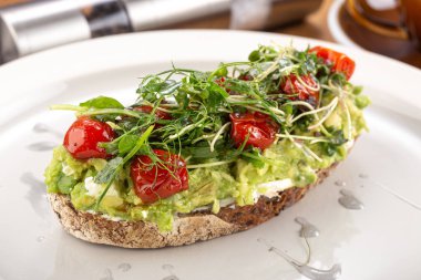 Avokado ile çıtır bruschetta. Faydalı Diyet Kadehleri. Avokado, somon balığı ve vişneli domates. Siyah çavdar ekmekli sandviç ve baharatlı avokado kreması.
