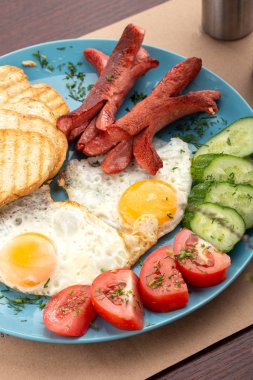 Ev yapımı lezzetli amerikan kahvaltısı. Yanında kızarmış yumurta, tost, sosis, meyve, çilek reçeli, kruvasan.