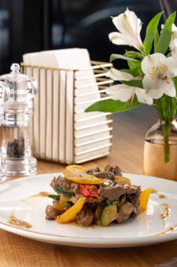 Lezzetli taze salata. Dana etli salata, domates, biber, salatalık ve mantarlı ahşap zemin. Restoran yemekleri, kapatın. Et salatası. Salatayı sıcak dana etiyle kapatın..