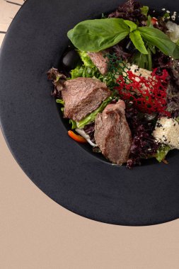 Lezzetli taze salata. Dana etli salata, biber, ahşap arka planda marul. Restoran yemekleri, kapatın. Et salatası. Salatayı sıcak dana etiyle kapatın..