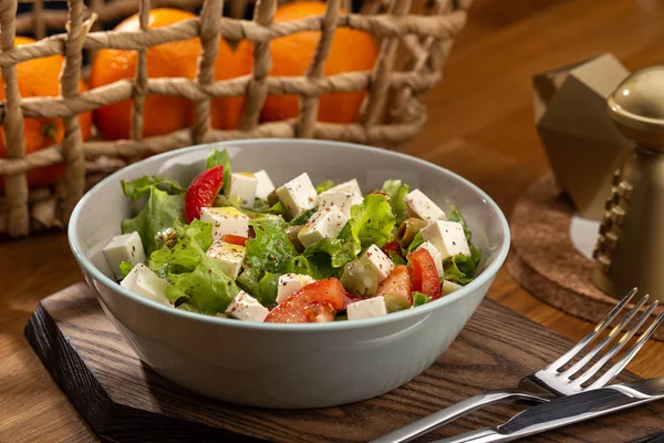 Delicious fresh salad. Greek salad with feta cheese, organic olives, juicy tomatoes, red pepper, red onion, cucumber and lettuce. Greek salad with fresh vegetables. Close up view on Salad. Healthy, diet tasty summer dish