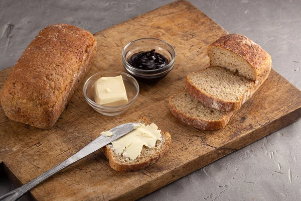 Fresh bread with butter, jam on a table. breakfast. Slice of bread with butter, jam on wooden table