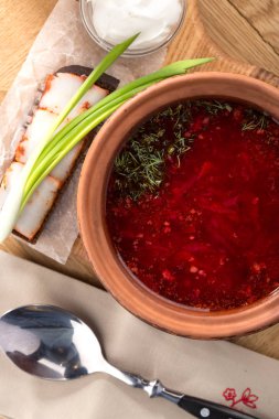 Ahşap masada ekşi kremalı borş. Bir kase pancar kökü çorbası. Kasesinde beyaz fasulye olan geleneksel Ukrayna Rus çorbası. Pancar çorbası. Bir tabak kırmızı pancar kökü çorbası..