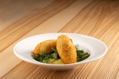 Maydanoz yapraklı tavuk pirzolası. Ukrayna geleneği yemekleri. Tavuk Kiev, Ukrayna mutfağı. Tereyağı ve otla doldurulmuş ekmek kırıntılarının içinde patates püresi ile servis edilen tavuk pirzolası. Kapat.