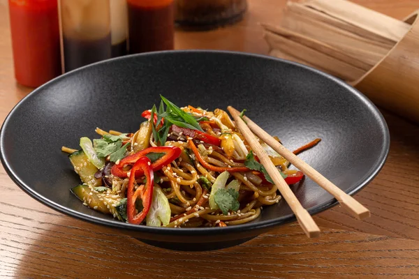 Stir fry with soba noodles, vegetables. Asian healthy food, stir fried meal in bowls. Spicy noodles. Vegetarian Noodles or Vegetable Hakka Noodles or Chow Mein. Indo-chinese cuisine hot dish