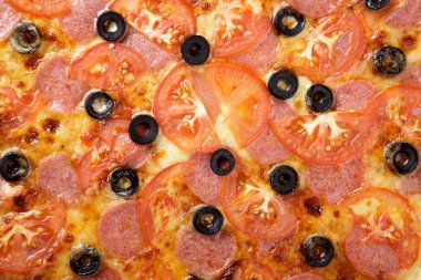 Lezzetli pizza. Domuz pastırmalı, sosisli, salamlı, pepperonili ve zeytinli büyük boy etli pizza. Akşam yemeği için ahşap masada ev yapımı lezzetli İtalyan pizzası. İtalyan mutfağı.