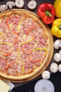 Lezzetli pizza. Domuz pastırmalı, sosisli, salamlı, pepperonili ve zeytinli büyük boy etli pizza. Akşam yemeği için ahşap masada ev yapımı lezzetli İtalyan pizzası. İtalyan mutfağı.
