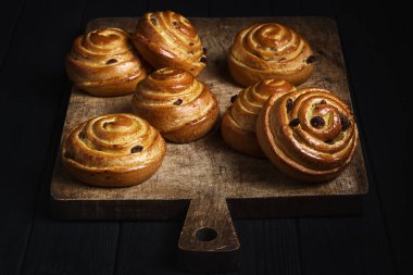 Meyveli bukleler, reçel, böğürtlen, tatlı yumuşak peynir. Tahtada puf böreği ve siyah ahşap bir masa. Taze Fransız ev yapımı puf bukleli börek. Sıcak Taze Tereyağı Yuvarlakları.