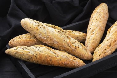 Fırından çıtır çıtır baget, fırından çıkıyor, fırından. Tahtada taze ev yapımı ekmek var. ekmek - taze pişmiş baget ekmeği, menü konsepti. yiyecek arka planı.