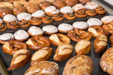 Masada değişik taze ekmekler var. Ahşap masada taze fırın ürünleri çeşitleri.