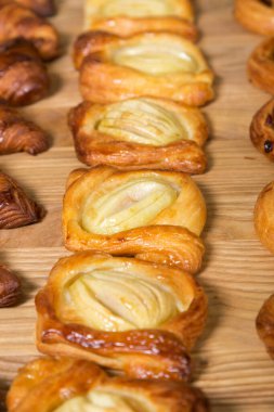 Masada değişik taze ekmekler var. Ahşap masada taze fırın ürünleri çeşitleri.